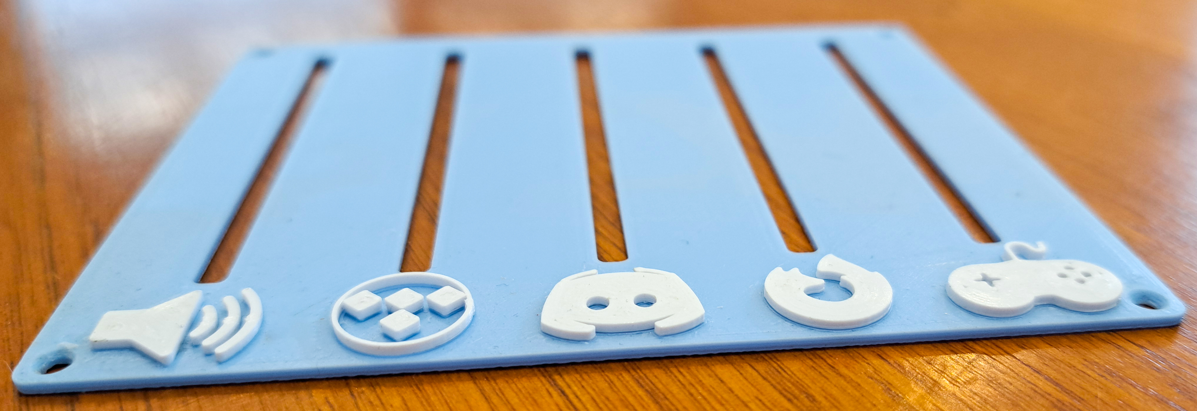 Blue 3D printed audio mixer top plate with white raised icons before final assembly